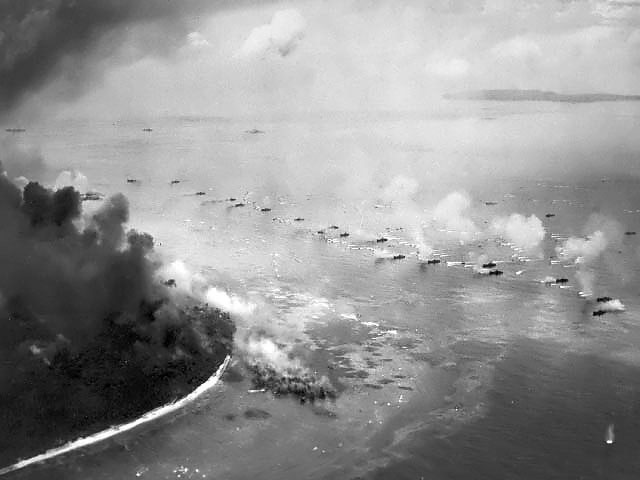 The first wave of LVTs moved toward Peleliu invasion beaches, Palau Islands, 15 Sep 1944; note the bombardment lines consisted of LCIs, cruisers, and battleships; photo taken USS Honolulu aircraft