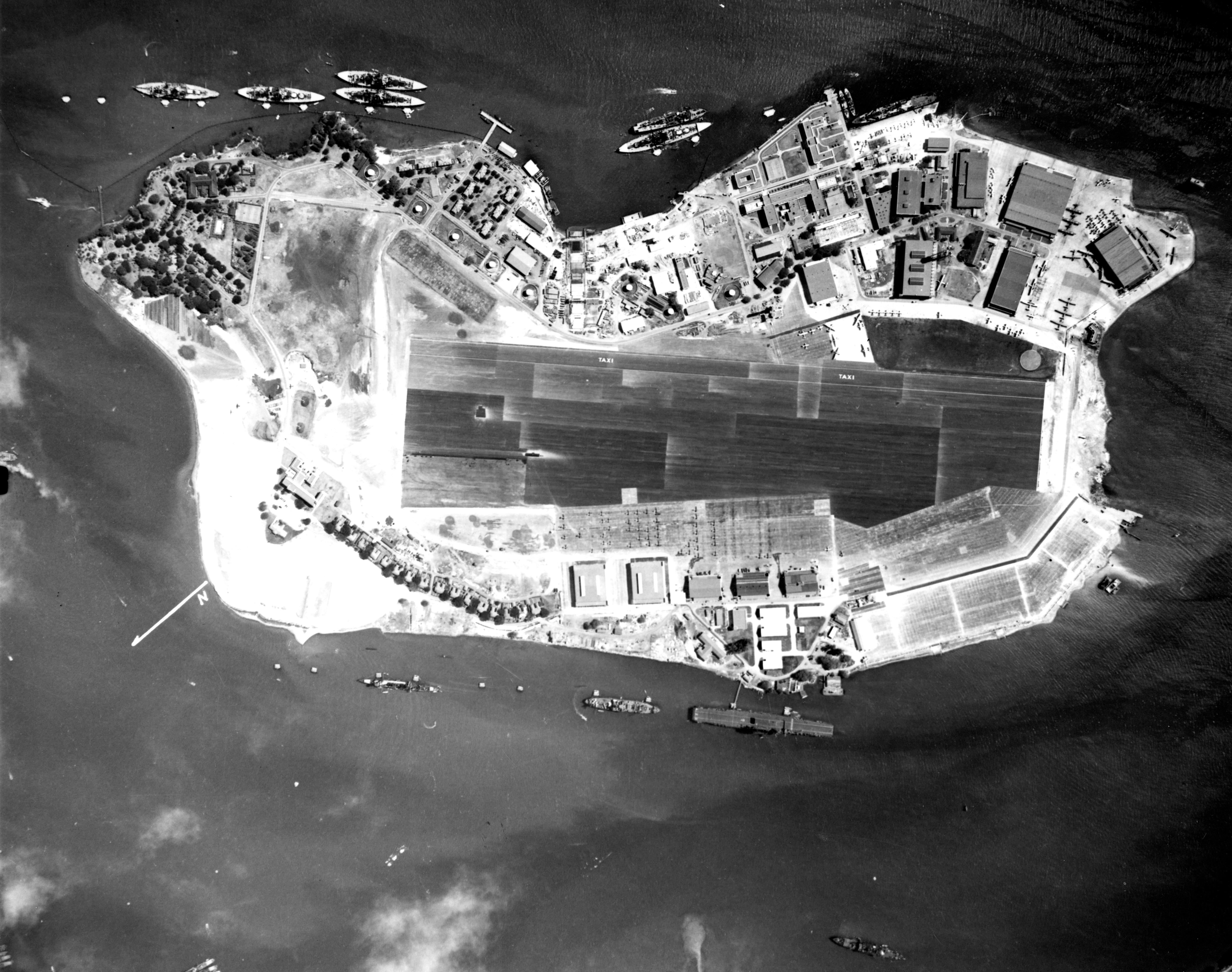 Vertical aerial photograph of Ford Island, Pearl Harbor, US Territory of Hawaii, 10 Nov 1941; note Battleship Row on top, USS Lexington at bottom, and PBY aircraft at upper right