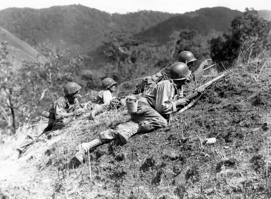 US 25th Division squad leader pointing at a suspected Japanese position at the edge of Baleta Pass, near Baguio, Luzon, Philippine Islands, 23 Mar 1945
