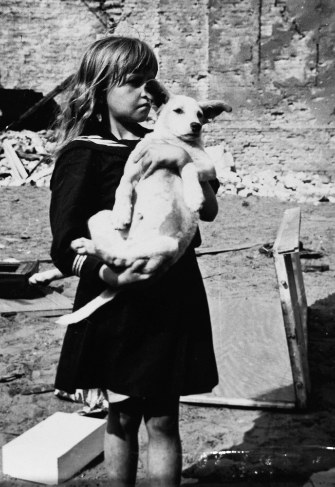 A girl holding her dog, 8 Żelazna Street, Warsaw, Poland, 5 Sep 1939