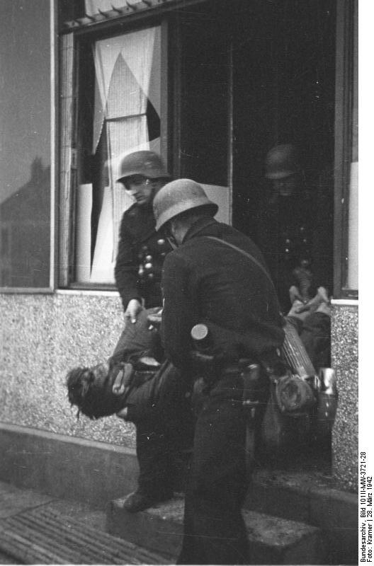 German naval personnel removing a killed British commando from a house, Saint-Nazaire, France, 28 Mar 1942