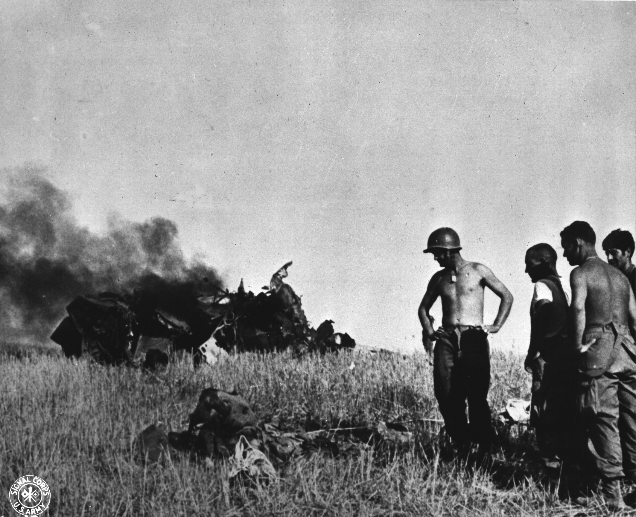American soldiers looking at a dead German pilot and his wrecked aircraft near Gela, Sicily, Italy, 12 Jul 1943