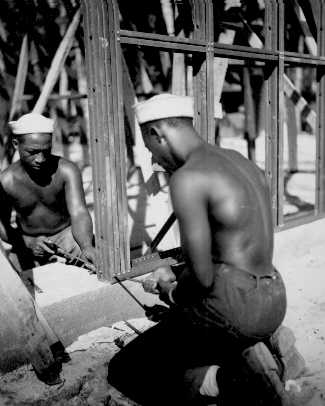 African-American men of US 34th Construction Battalion constructing prefabricated steel warehouse at Halavo Seaplane Base, Florida Island, Solomon Islands, 19 Sep 1943