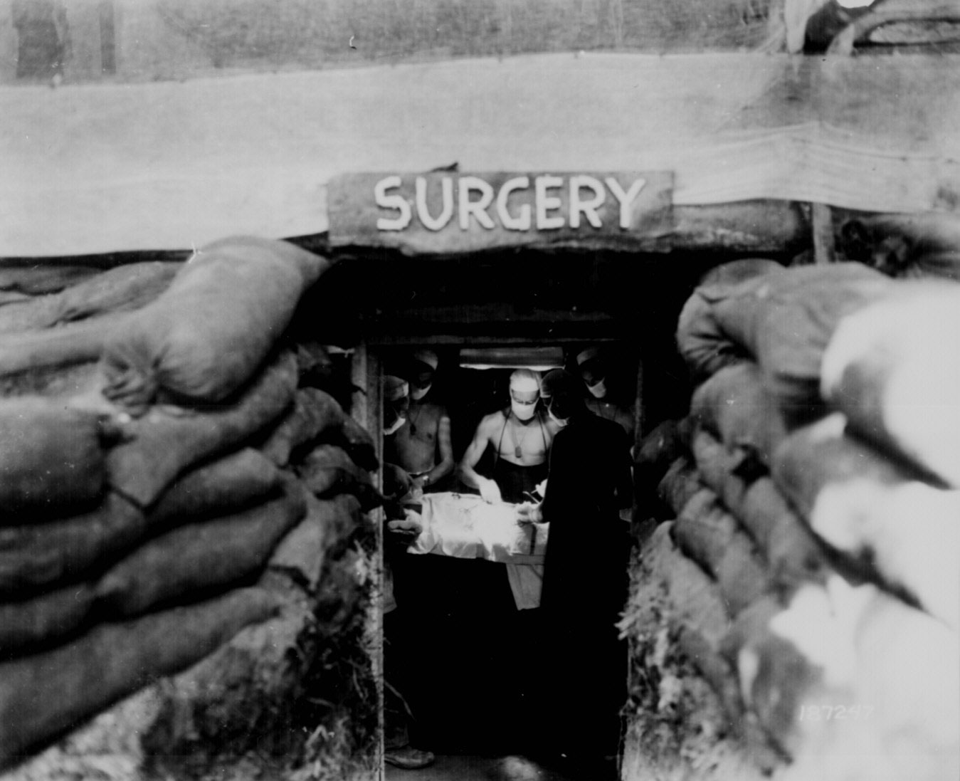 An American surgeon operated on a soldier wounded by Japanese sniper fire, Bougainville, 13 Dec 1943