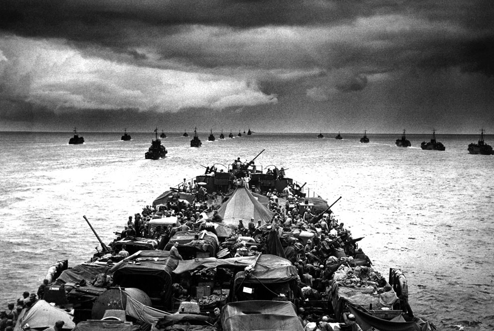 Columns of troop-packed American LCI landing craft in the wake of a USCG-manned LST en route to Cape Sansapor, New Guinea, mid-1944