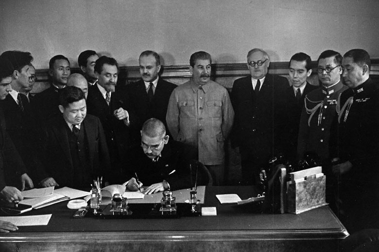 Japanese Foreign Minister Yosuke Matsuoka signing the Soviet-Japanese Neutrality Pact, Moscow, Russia, 13 Apr 1941, photo 1 of 3; note Vyacheslav Molotov and Joseph Stalin in background