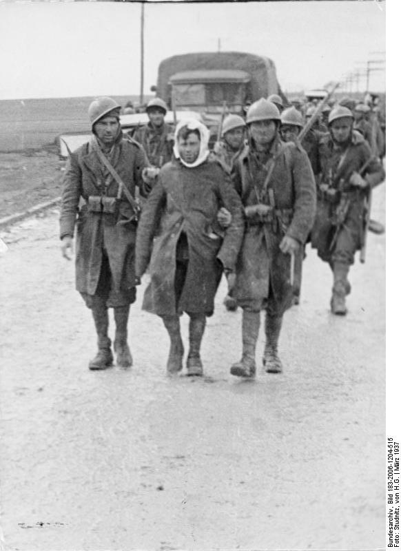 Wounded Spanish Nationalist soldier supported by two comrades near the end of the Battle of Guadalajara, Spain, 29 Mar 1937