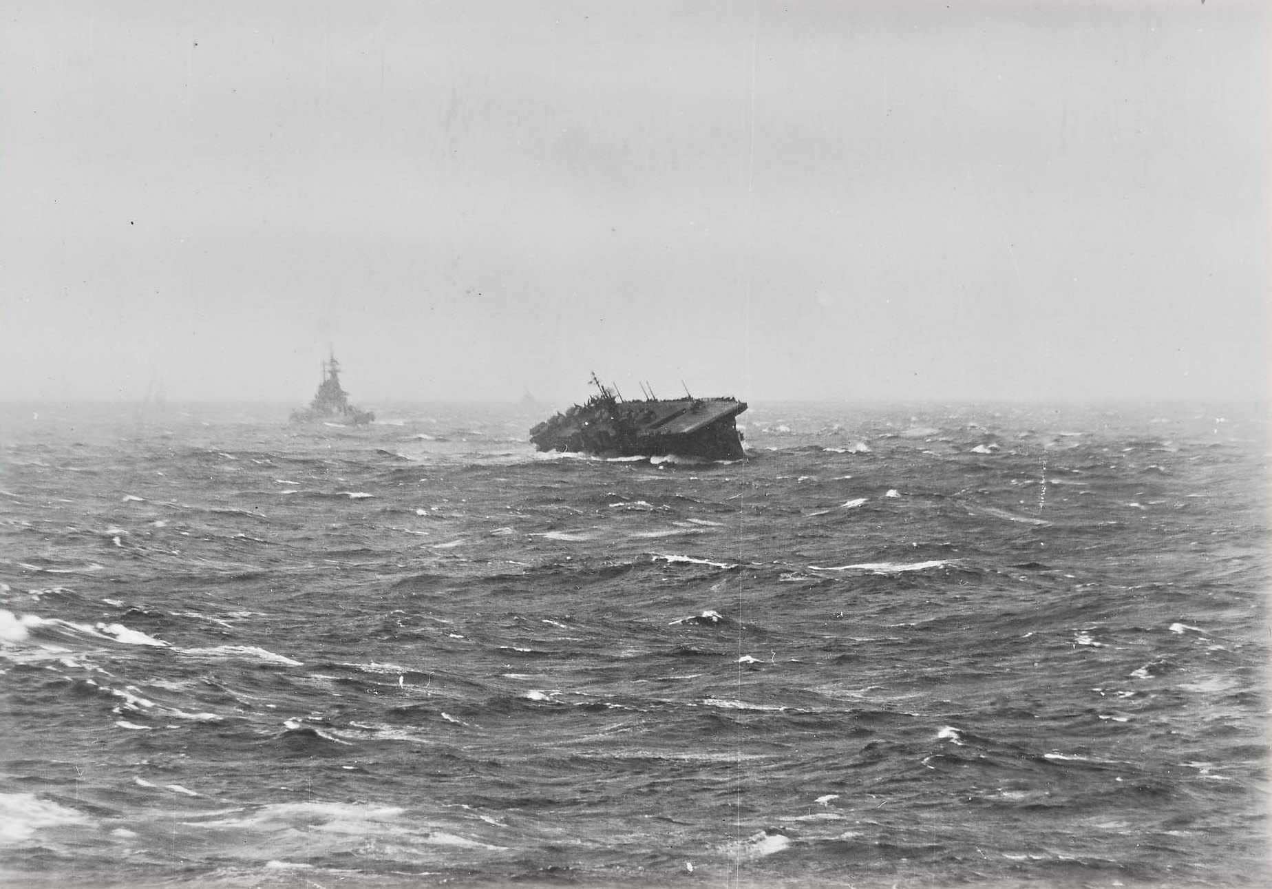 USS Langley in heavy seas in the South China Sea in the morning of 13 Jan 1945. Note the trailing USS Washington riding the storm much better.