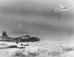 B-17G Fortresses of the 96th Bomb Squadron are joined by a damaged P-38J Lightning fighter on the return from a mission, before 10 Jun 1944. Note feathered engine on the P-38 with oil stains covering the engine cowling