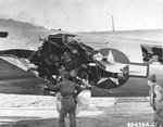 Crews examine flak damage to B-17G Fortress at RAF Bassingbourn, Cambridgeshire, England, UK. Damage sustained on mission to Munich, Germany, Jul 6 1944. Note "Mickey" pathfinder radar dome in place of ball turret.