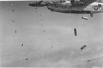 B-24J Liberators of the 579th Bomb Squadron drop incendiary bombs made from fighter plane drop tanks filled with napalm on targets near Royan, France, Apr 15 1945. Note the smoke marker dropped by the lead aircraft.