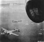 B-24M Liberator “Top o’ the Mark” and other bombers of the 23rd Bomb Squadron over Allied invasion fleet at Balikpapan, Borneo, July 2 1945.