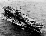 USS Enterprise with wartime camouflage under way with F6F Hellcats and SB2C Helldivers on her flight deck, 1944