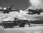 P-47D Thunderbolt “Big Squaw” and another P-47 of the 19th Fighter Squadron make a low level pass over East Field, Saipan, Oct 1944. Note IH M-5 Truck and T/5 James B Lazar from the 805th Aviation Engineer Battalion.