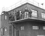 The 401st Bomb Group’s control tower at RAF Deenethorpe, Northamptonshire, England, UK, Feb 26 1945. Note a US Navy Captain among the group of observers.
