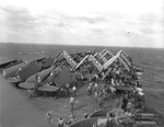 TBM-1C Avengers, SB2C Helldivers, and F6F-5 Hellcats of Air Group 20 are spotted on the forward flight deck of the Fleet Carrier USS Enterprise, Aug-Nov 1944. Note 40mm Bofors anti-aircraft guns.