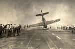 Deck crews aboard the training aircraft carrier USS Sable man lines to right an FM-2 Wildcat that had nosed completely over. Lake Michigan, United States, 1943-45. Photo 3 of 3.