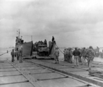 LCT-525 delivering a half-track onto a pontoon causeway pier at Utah Beach, Normandy, France, Jun 15 1944.  Half track is an M16 Anti-Aircraft gun mount of A Co, 376th AAA Battalion.