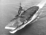 Aircraft carrier HMS Illustrious underway, 1942.  A Swordfish torpedo plane is on the flight deck and an admiralty disruptive camouflage scheme also extends across the flight deck.
