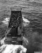 An LCM (Landing Craft Mechanized) loaded with troops shoves off from the troop transport and heads toward the shore at Iwo Jima, Mar 6, 1945.