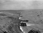 Overhead view of the landing beaches on Iwo Jima, covered with freshly landed supplies, Mar 1945