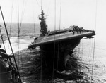 The carrier Franklin still listing badly after fires were brought under control following bomb hits aft that set off more bombs and fueled aircraft, 19 Mar 1945.