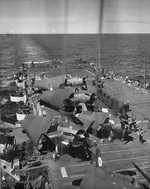 USS Belleau Wood after fires were put out and damaged aircraft were jettisoned after being struck by a special attack aircraft earlier in the day, off the Philippine Islands, 30 Oct 1944. Note hole in flight deck