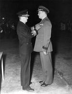 Commodore Leslie Gehres standing at attention while Vice Admiral Jack Fletcher presents him with the Legion of Merit award, Adak, Alaska, 19 Jan 1944. Photo 2 of 2.