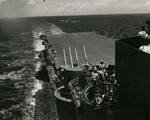 Looking aft from the signal bridge of USS Lexington (Essex-class) with 40mm Bofors mount and two 5-inch/38 mounts as F6F Hellcat approaches for a landing, Jun 1944