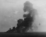 Smoke pouring from the Ticonderoga’s fires following a special attack aircraft crashing through the flight deck off Formosa (Taiwan) on 21 Jan 1945 that started stubborn fires on the hangar deck