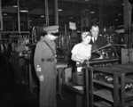 Chinese Army officer and an executive of the John Inglis and Company observing a female worker at the Inglis Toronto plant, Canada, 20 Aug 1943