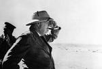 During an inspection tour to El Alamein, Egypt, Winston Churchill looks out across the desert toward the German lines, 19 Aug 1942.