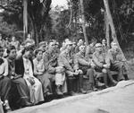Lieutenant General Joseph Stilwell, Lieutenant General Sun Li-jen, and others attending a Christmas holiday program, Ningam Sakan, northern Burma, 25 Dec 1943