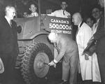 R. Samuel McLaughlin, president of General Motors of Canada, holding a lug wrench in a publicity photo commemorating completion of Canada’s 500,000th military vehicle, a Chevrolet CMP battery charging lorry.