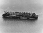 Escort carrier USS Long Island in San Francisco Bay, California, United States, on 10 Jun 1944 with a deck load of F6F Wildcat, SBD Dauntless, and J2F Duck aircraft bound for Pearl Harbor, Hawaii.
