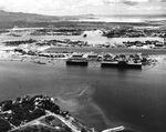 Aerial view of Ford Island from over Pearl City Peninsula looking toward Diamond Head in the distance, 1 Aug 1942. Escort carrier USS Long Island and Yorktown-class carrier USS Hornet are moored to Ford Island.