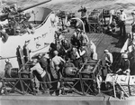 Prisoners from the German submarine U-490 on the destroyer escort USS Inch awaiting transfer to USS Croatan, 12 Jun 1944. Note the streamlined depth charges for fast-sinking and guard with a Reising M50 submachine gun.