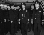 King George VI aboard USS Ancon accompanied by US officers Rear Admiral John Hall, Jr. and Commander Mead Pearson, 25 May 1944