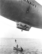 United States Navy K-class airship, probably based at Lakehurst, New Jersey, United States, engaged in a drill to lower supplies to survivors in a small boat, Jan 1943.