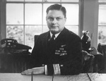 Portrait of Commodore Leslie Gehres sitting at his desk as commander of Fleet Air Wing Four, Adak, Alaska, mid-1944.