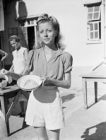 Wendy Pamela Rossini, recently freed Australian internee of Stanley Internment Camp, displaying the typical daily rice ration for her family of 5 during Japanese occupation, Hong Kong, Aug-Sep 1945