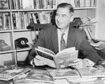 Publicity photo of Theodor Geisel (Dr. Seuss) at his desk with some of his books, 1957.