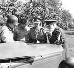 Generals Omar Bradley, Bernard Montgomery, and Miles Dempsey with Air-Marshal Trafford Leigh-Mallory in conference on the hood (bonnet) of Montgomery’s Humber Super Snipe staff car, near St. Lô, Normandy, France, 5 Aug 1944.