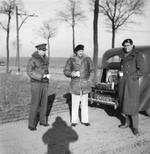 Field Marshal Bernard Montgomery and members of his staff stop on a Belgian road for a break, 27 Dec 1944. Note picnic set in trunk (boot) and the shadow of photographer Sgt John Morris.
