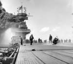 Smoke pouring out of the uptakes of the carrier USS Yorktown after being struck by Japanese bombs during the Battle of Midway, 4 Jun 1942.