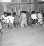 Third grade arithmetic class with no desks or other school facilities at the Manzanar Relocation Center for deported Japanese-Americans, Inyo County, California, United States, 1 Jul 1942