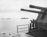 As seen from the flight deck of the USS Hancock near the No. 1 5-inch mount, sailors look at the nearby carriers Intrepid, Cabot, and Belleau Wood while anchored at Ulithi, Caroline Islands, 9 Nov 1944.