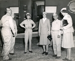 First lady Eleanor Roosevelt, center, upon arrival at Espiritu Santo, New Hebrides during her tour of the South Pacific on behalf of the Red Cross, 14 Sep 1943. Vice-Admiral Aubrey Fitch is to her left.