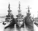 Cruisers USS Salt Lake City, Pensacola, and New Orleans nested together at Pearl Harbor in Berth B-3, 30 Oct 1943. Note the radar antennae, gun directors and eight-inch guns on these three heavy cruisers.