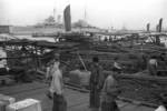 Chinese workers on a pier, Shanghai, China, mid-1937, photo 5 of 5; note HMS Cumberland in background